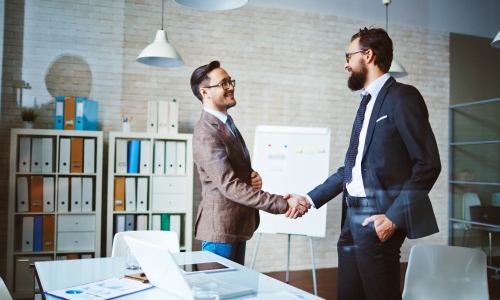 Two business men shaking hands in an office