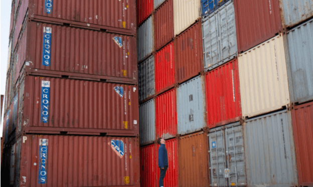Person standing next to containers to represent using Shipa Freight as a freight forwarder