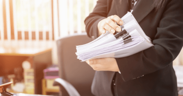 Person checking through a stack of different kinds of bills of lading