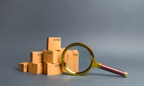 Magnifier over cardboard boxes for the search for products standards by Shipa Freight