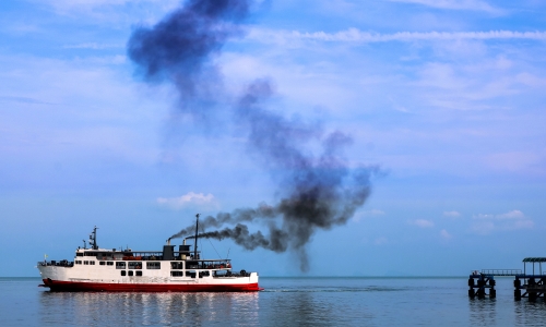 Boat rejecting a big cloud of dark smoke containing great quantities of CO2