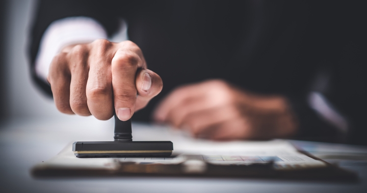 Close-up shot of man stamping a document