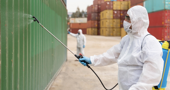 Person spraying the product on the container to disinfect it