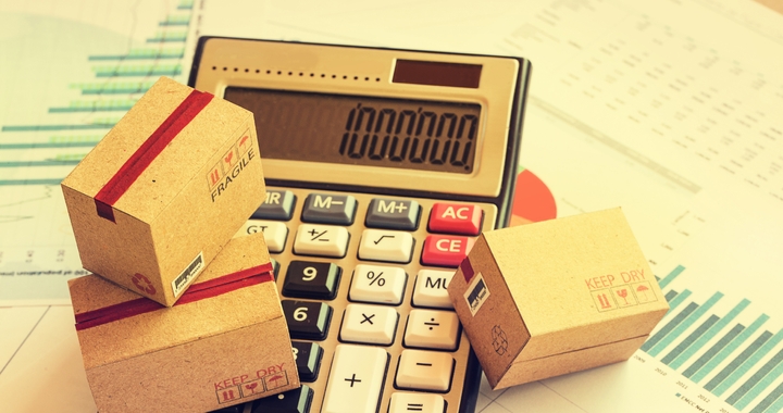Calculator with boxed on top to represent calculating the cost of ocean shipping