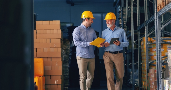 Two workers in a warehouse to represent  freight carriers.